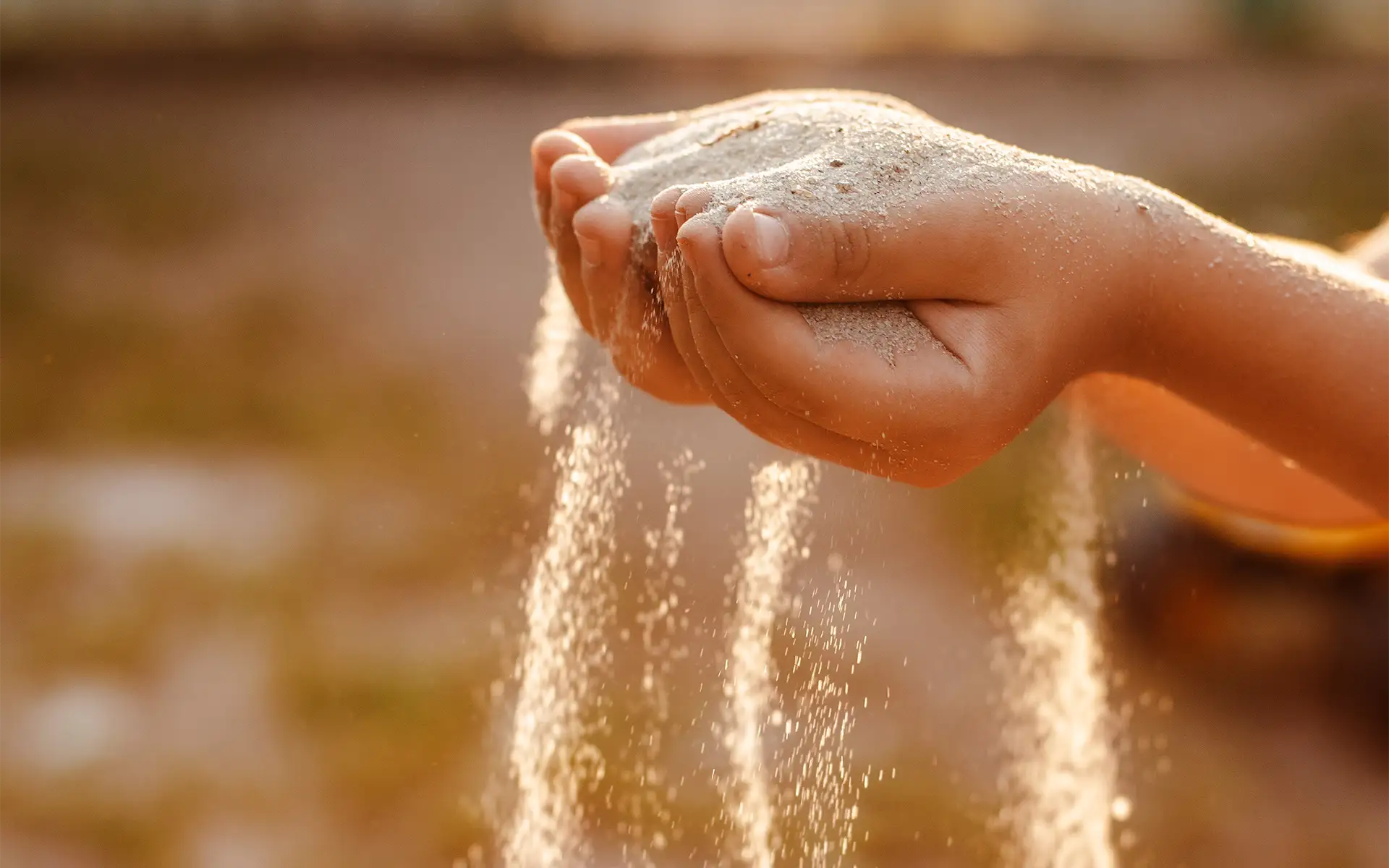 A child engaged in sensory occupational therapy plays with sand
