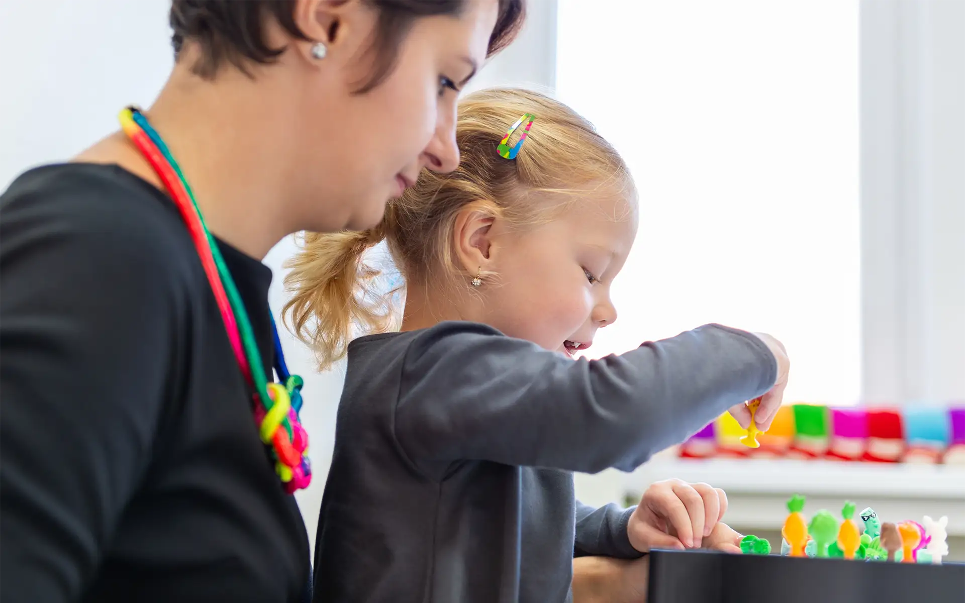A girl in child occupational therapy session doing sensory exercises with her therapist